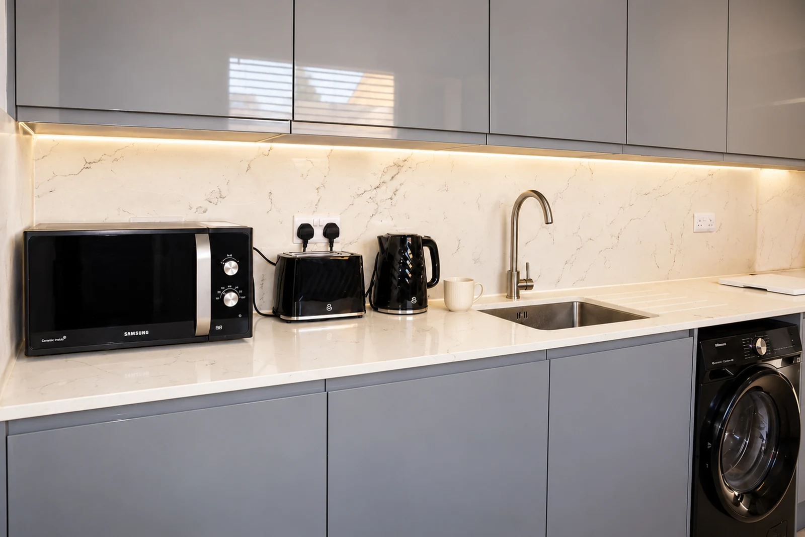 Shared kitchen for Rooms 1–5, with a microwave, kettle and toaster. Washing machine use is by arrangement; it is normally reserved for the cleaning team.
